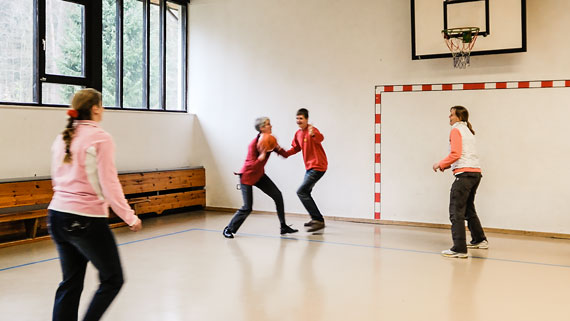 Foto: Die Leiterin unseres Hauses, Frau Benath (im Ballbesitz), beim Basketball im Angriffsmodus